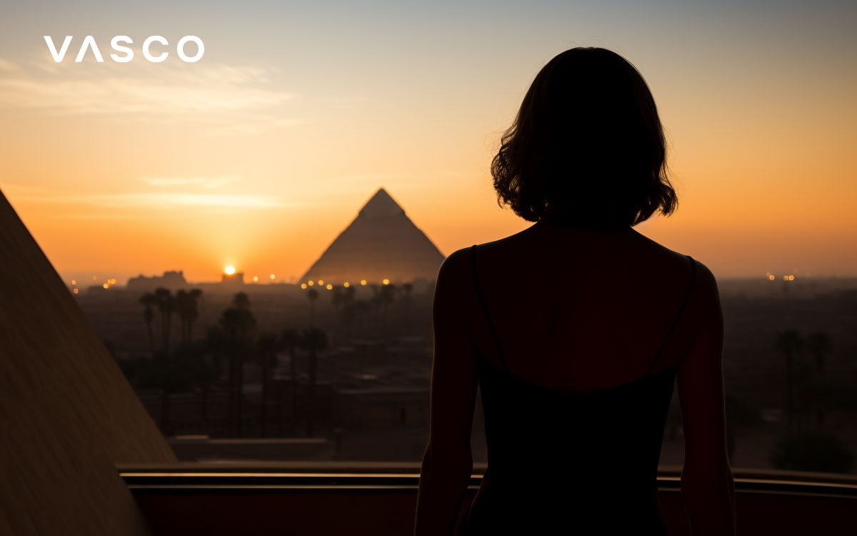 Femme debout sur une terrasse sur fond de pyramides de Gizeh.