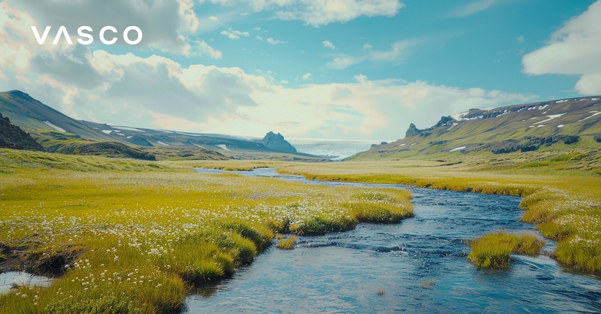 La photo montre une rivière islandaise s'écoulant au travers de prairies luxuriantes.