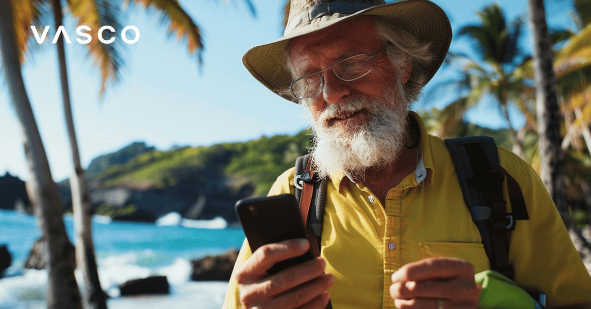 Un homme âgé qui regarde son téléphone près de la mer