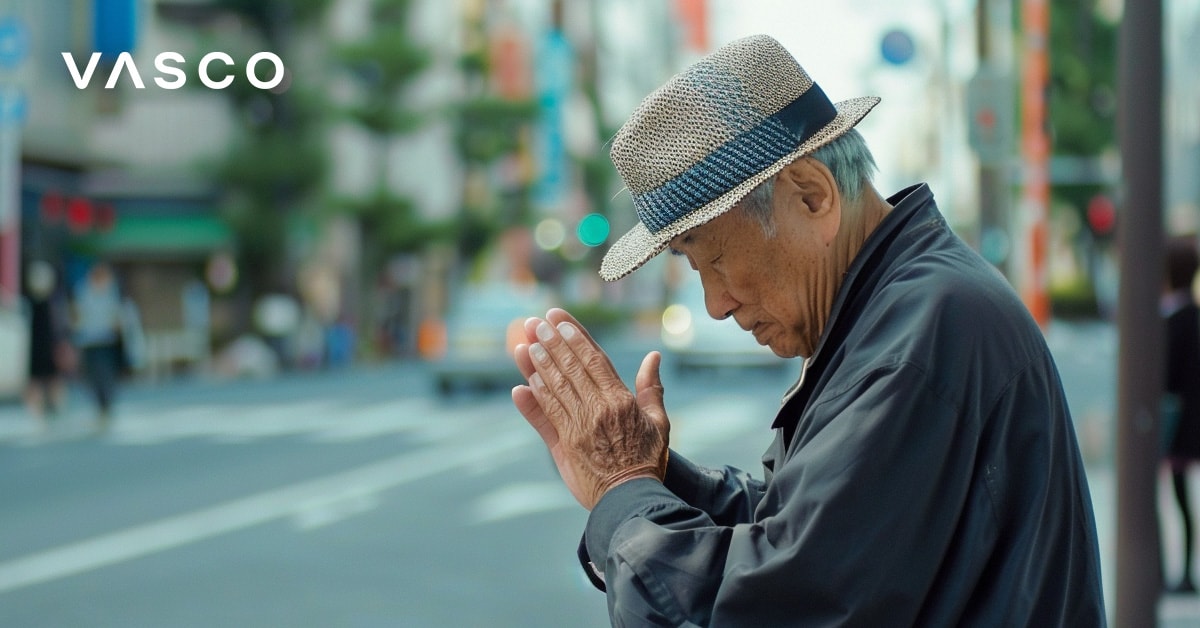 Un homme âgé s'inclinant avec les mains jointes, représentant la façon de dire bonjour en japonais.