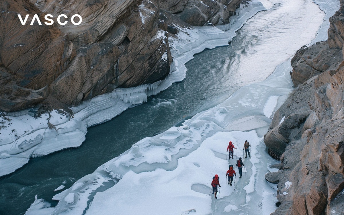  Un groupe de randonneurs marchant sur une rivière gelée à travers un canyon enneigé.