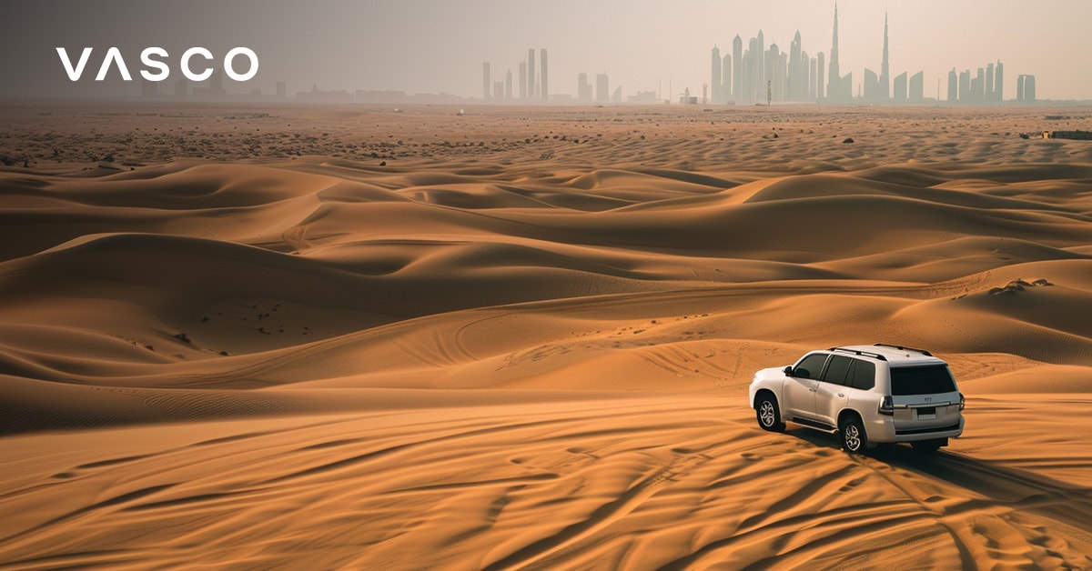 SUV driving through the Dubai desert with city skyline in the distance