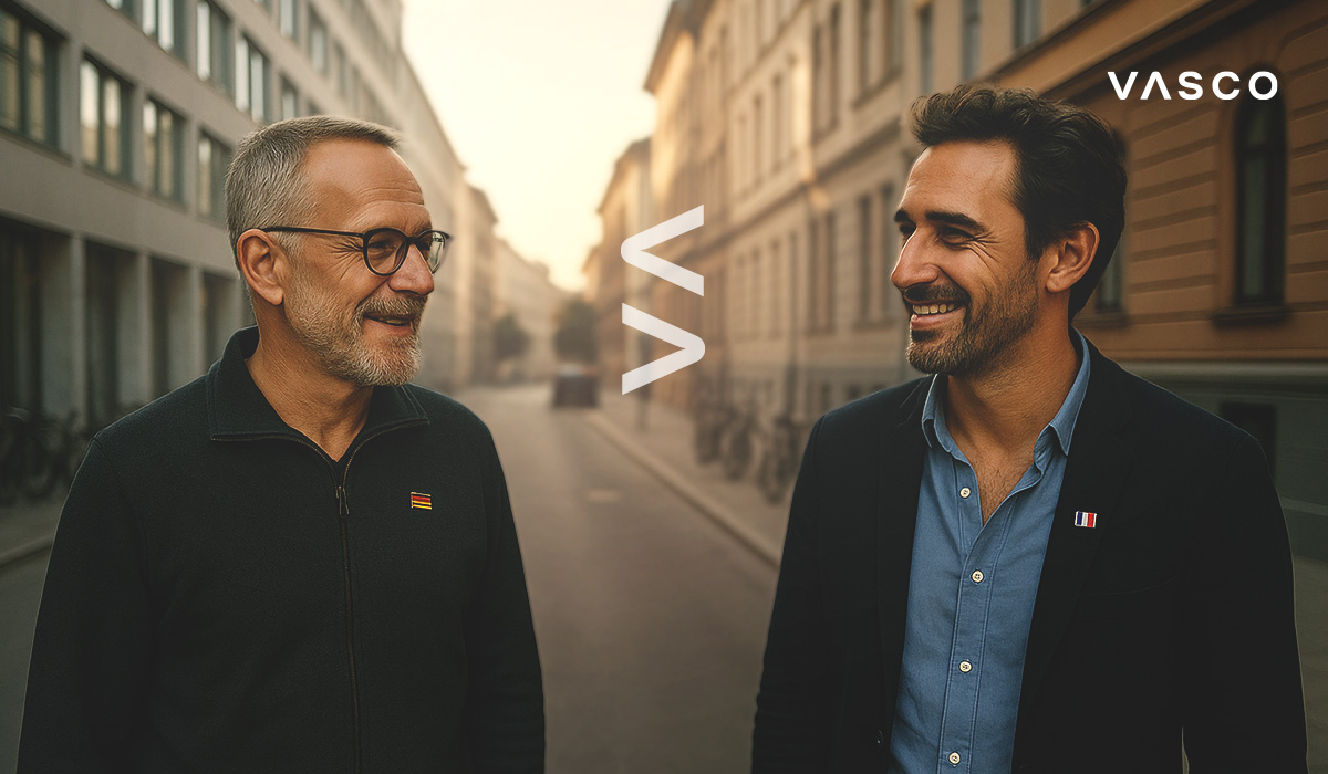 deux hommes se sourient, le logo VASCO se trouve entre eux