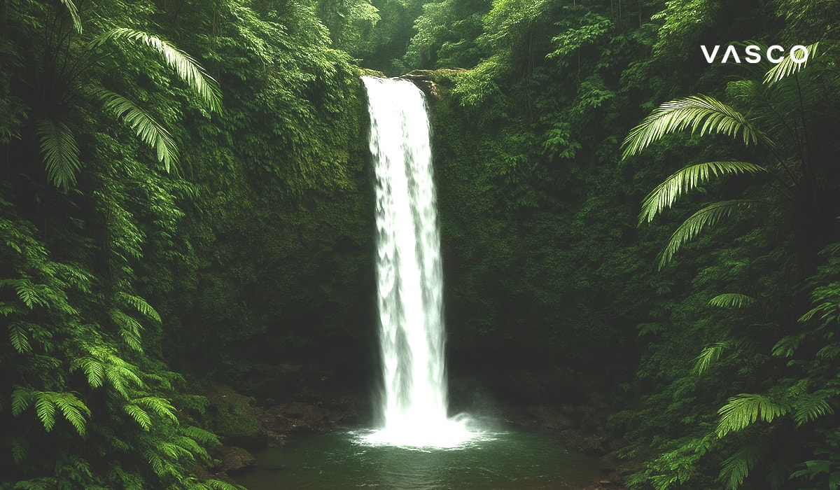 Une majestueuse cascade se déverse dans un bassin paisible au cœur d’une jungle tropicale dense et verdoyante.