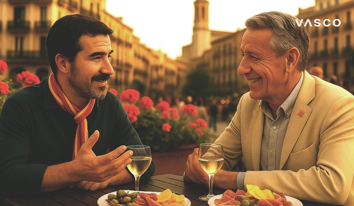 Deux hommes souriants et joyeux partagent un repas et une conversation sur une terrasse de restaurant.