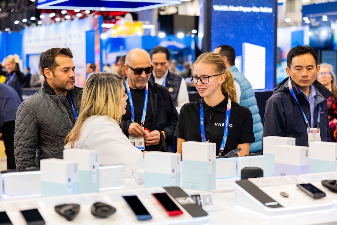 CES 2026 Un groupe de personnes souriantes discute devant le stand Vasco Electronics au CES 2026.