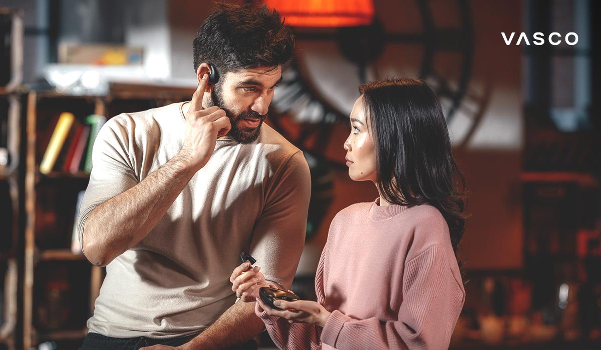 4332cbc7-1266-485d-8cb6-e0dbd908a9fd un homme et une femme utilisant des écouteurs traducteurs IA pour une conversation multilingue en temps réel