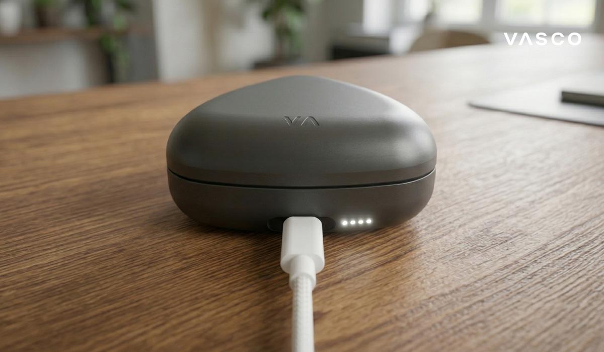 étui de charge des écouteurs Vasco Translator avec câble sur un bureau en bois